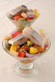 Salad with pieces of herring, white bread with vegetables and herbs