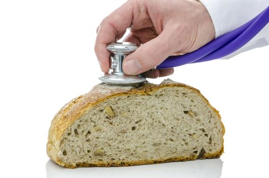 Male hand holding stethoscope on a buckwheat bread. Isolated on white background.