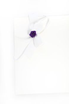 Image of a purple rose on white fabric.