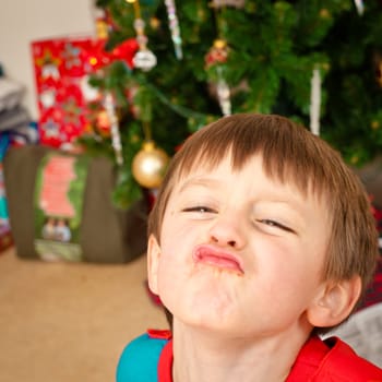 A young boy in front of a christmas tree on christmas morning