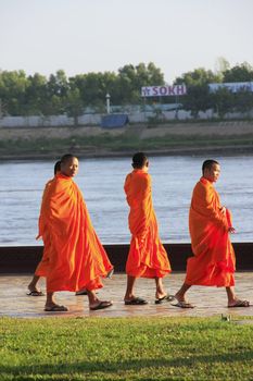 Buddhist monks walking along Mekong river, Phnom Penh, Cambodia