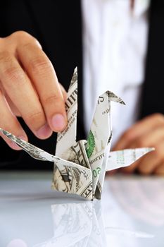 business man hand holding origami paper cranes, money concept