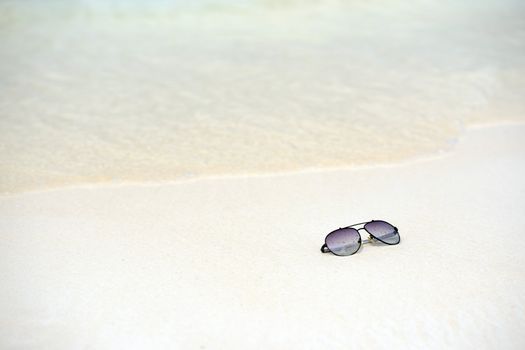 sunglasses on the white sand beach