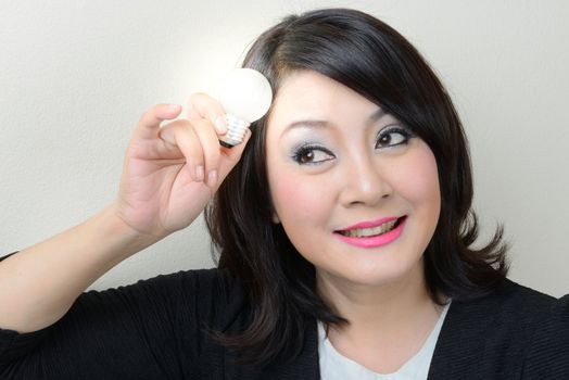 Smiling businesswoman having an idea with bright light bulb over her head