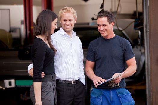 A happy customer couple receiving repair summary from mechanic