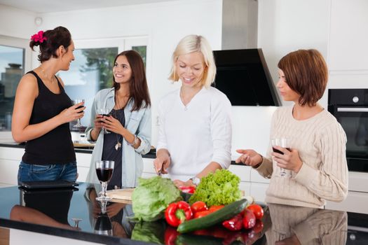 Group of happy female friends in kitchen