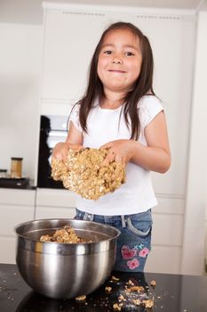 Young female child with hands full of cookie dough