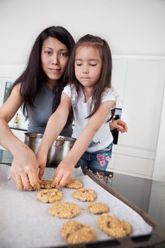 Portrait of mother and child in kitchen making cookies