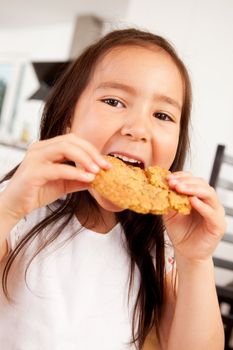 Cute young girl eating a large monster cookie