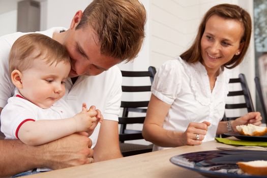 A happy family eating a meal together with mother father and son