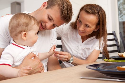 Mother and father eating a meal with their young son