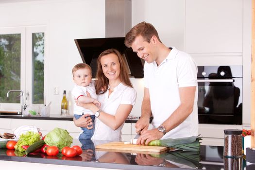 Happy family at home in the kitchen cooking, making a meal