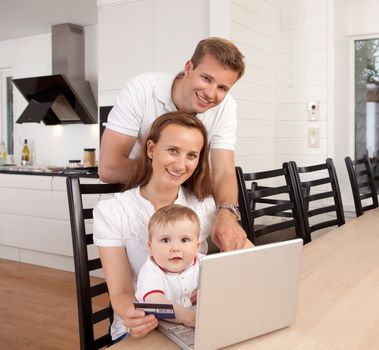 Happy family looking at the camera with a smile making an online purchase