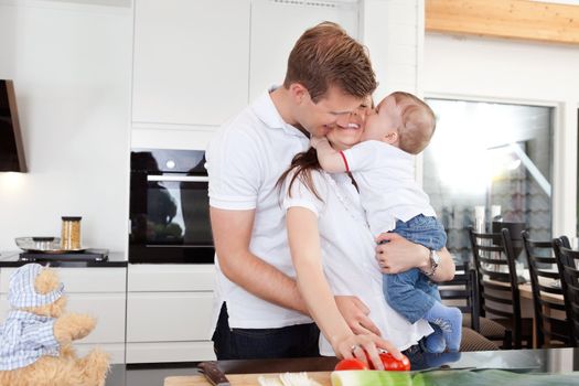 Happy family preparing a meal and getting a big hug