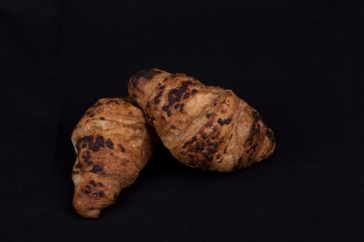 fresh chocolate croissant isolated on a black background