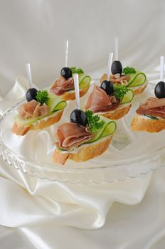 Mini sandwiches with ham and cucumber on a baguette