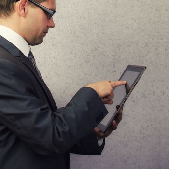 Businessman holding and working on digital tablet