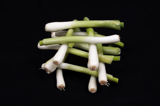 Fresh baby  leek on isolated on a black background