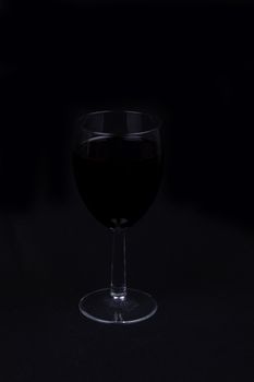 A glass of red wine isolated on black background,