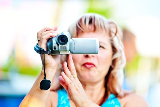 Woman shoots video with interest to the mini camcorder