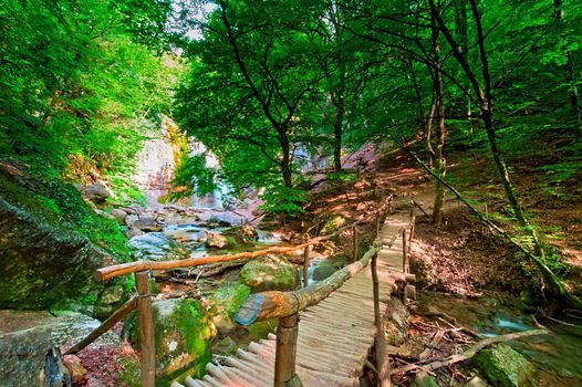 WoodWooden bridge at the waterfall Jur-Jur. Ukraine. Crimea.en bridge at the waterfall Jur-Jur. Ukraine. Crimea.