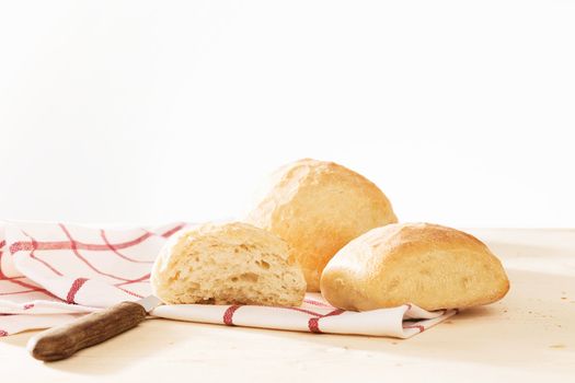 rustic wheat buns with a towel and a knife