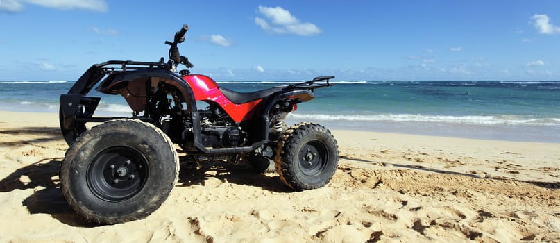 red quad on a caribbean beach in summer