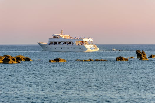 White cruise yacht in the sea at sunset light
