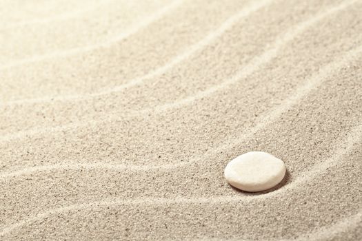 Sand background with white stone. Sandy beach texture