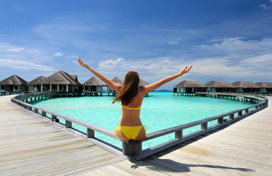 Woman on a tropical beach jetty at Maldives