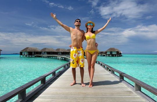 Couple on a tropical beach jetty at Maldives