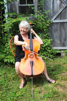 Female cellist with her cello outside.