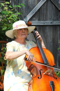 Female cellist with her cello outside.