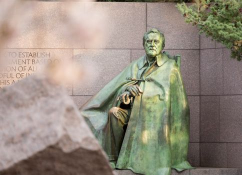 Early blurred Japanese cherry blossoms surround the monument to President Franklin Delano Roosevelt in Washington DC