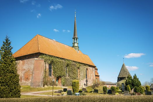 Red brick church and graveyard on sunny days in spring in the village Witzwort, Germany