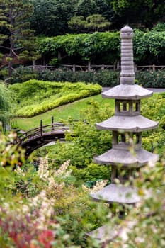 Japanese garden with ornamental stone garden lantern and bridge