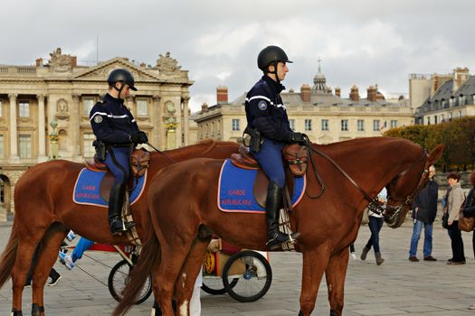 PARIS - NOV 10 : French policeman are patrolling on the champs elysees by horse in Paris, Nov 10, 2012, Paris, France. Two policemen riding on horseback cruise the streets in the area near the Carrousel Garden in Paris.