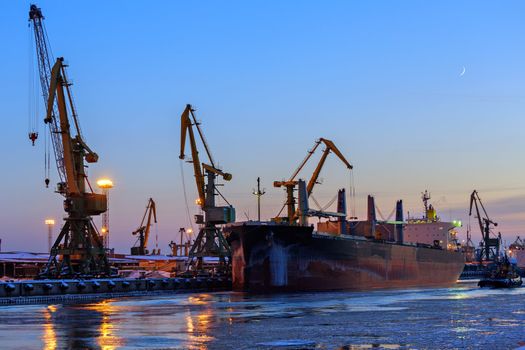 Cranes unloading a ship in a harbor