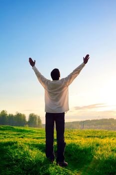 praying man silhouette on sunset background