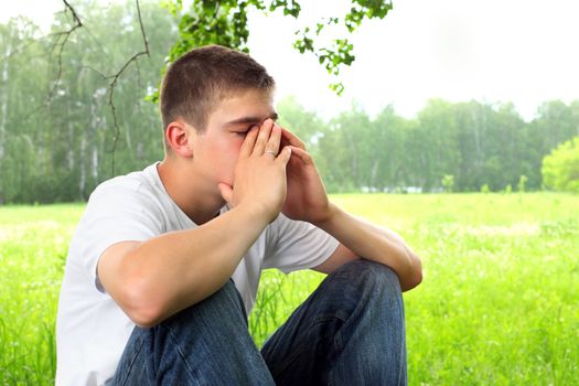 sad teenager sitting in the forest alone