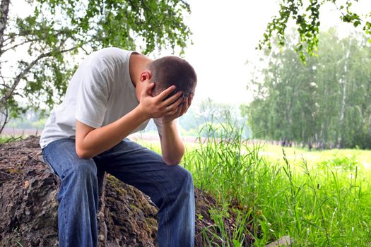 sad teenager sitting in the forest alone