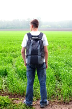 teenager with knapsack in the summer field