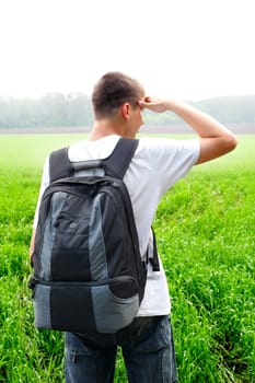 teenager with knapsack in the summer field
