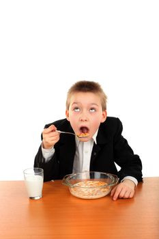schoolboy eating corn flakes isolated on the white