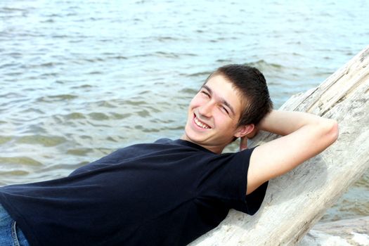 happy young man resting near the water