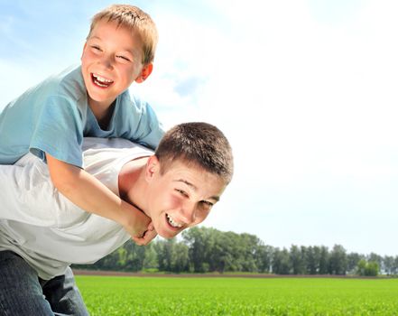 happy brothers playing in the summer field