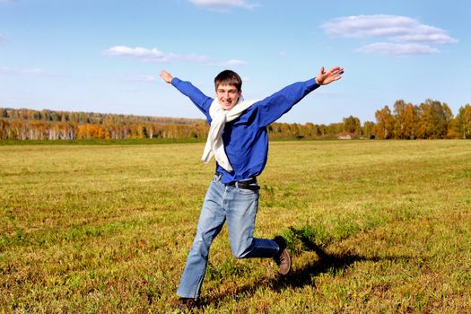 happy teenager running on the autumn field