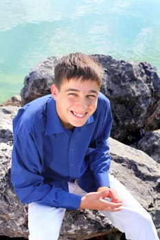 happy young man sitting near the water