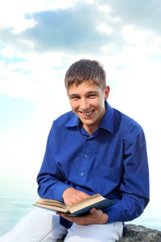 smiling teenager with a book outdoor