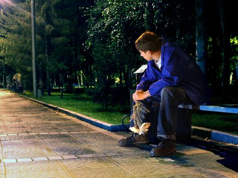 sad teenager in the night park with flowers